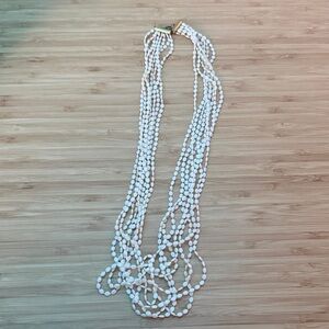 A multi-strand white Nassa shell lei necklace.